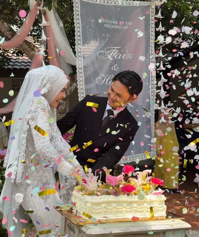 A couple beside a decorated cake as colourful confetti falls around them